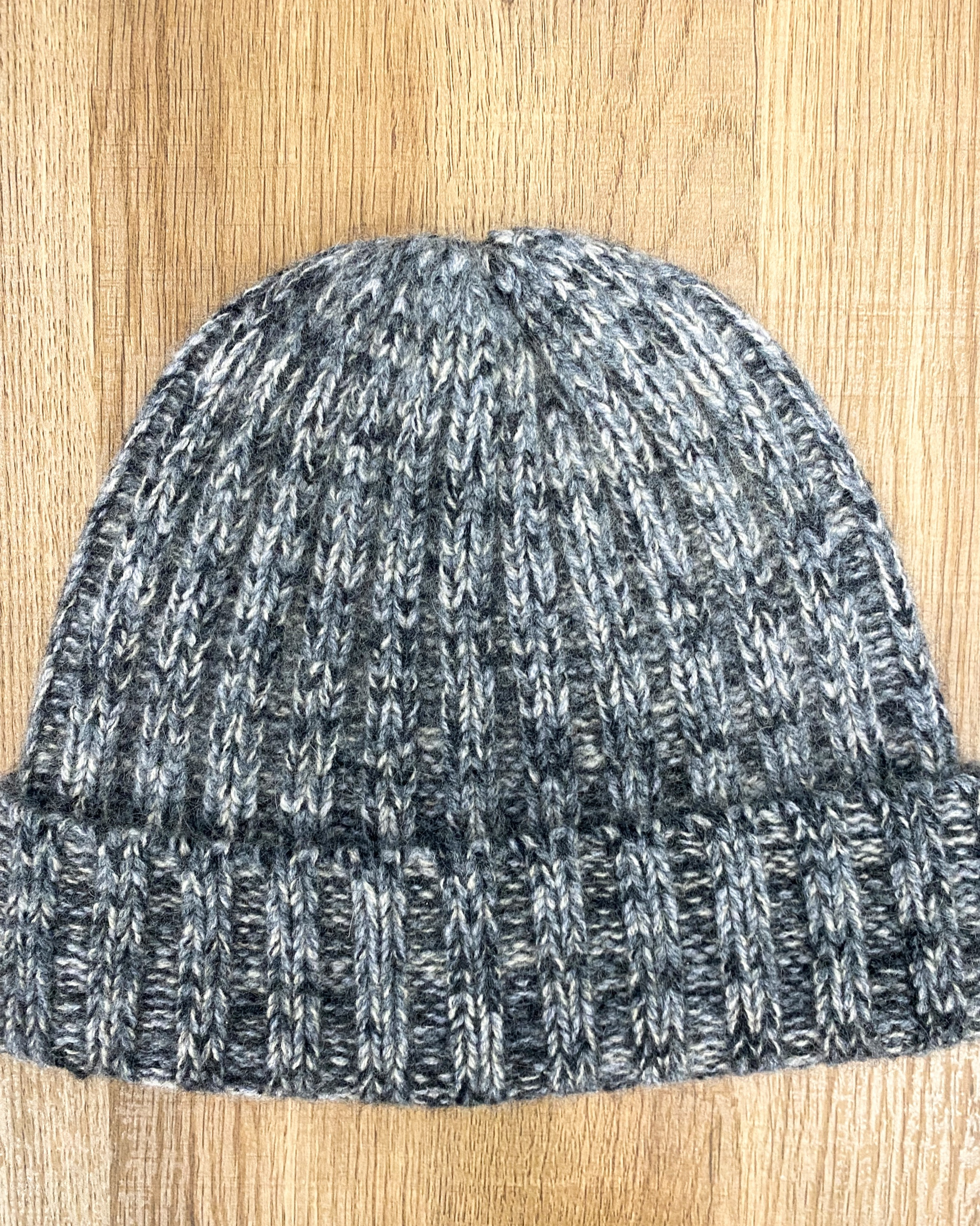 Mottled grey yak wool hat on neutral background, flat view
