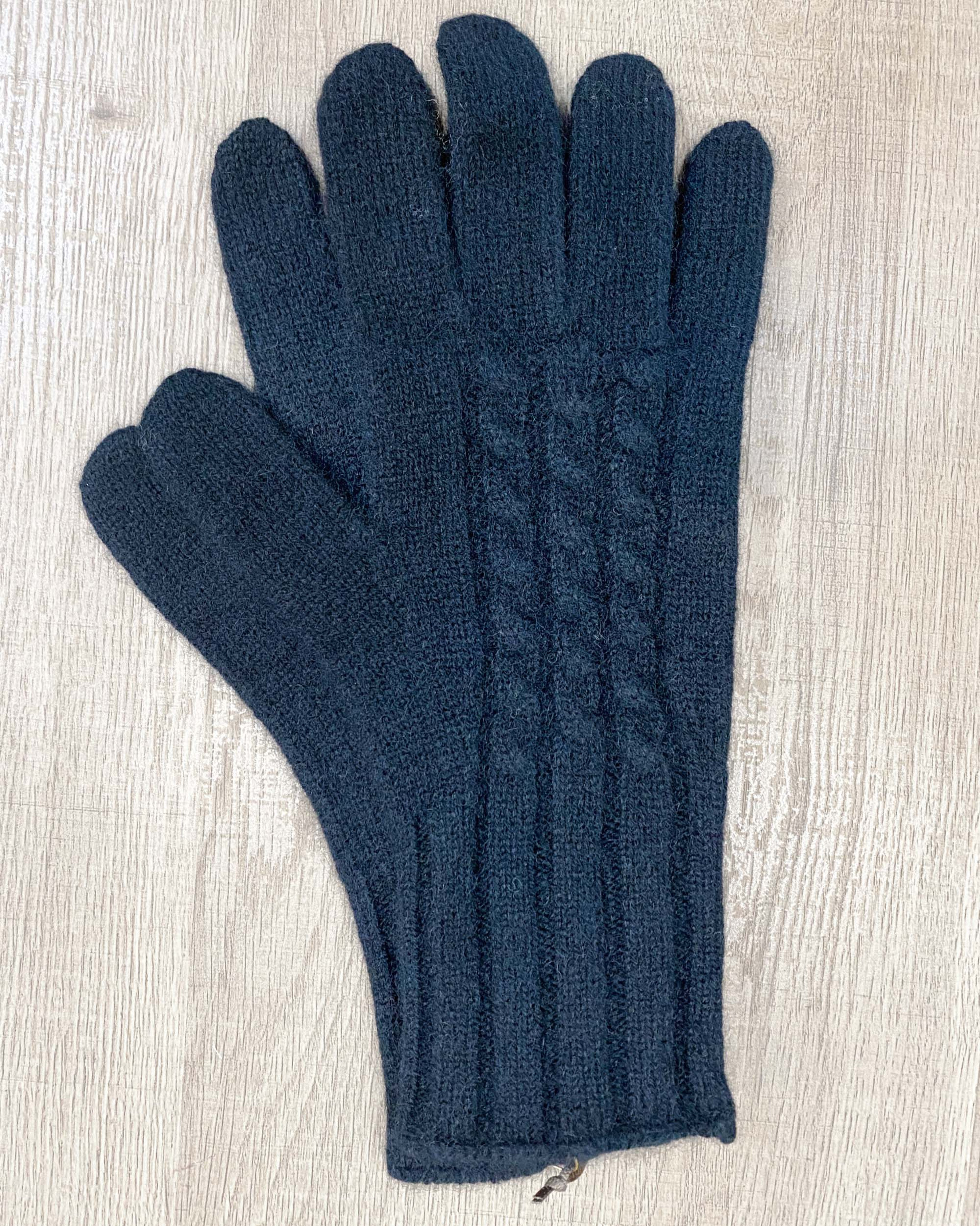 Black yak wool gloves on neutral background, flat view