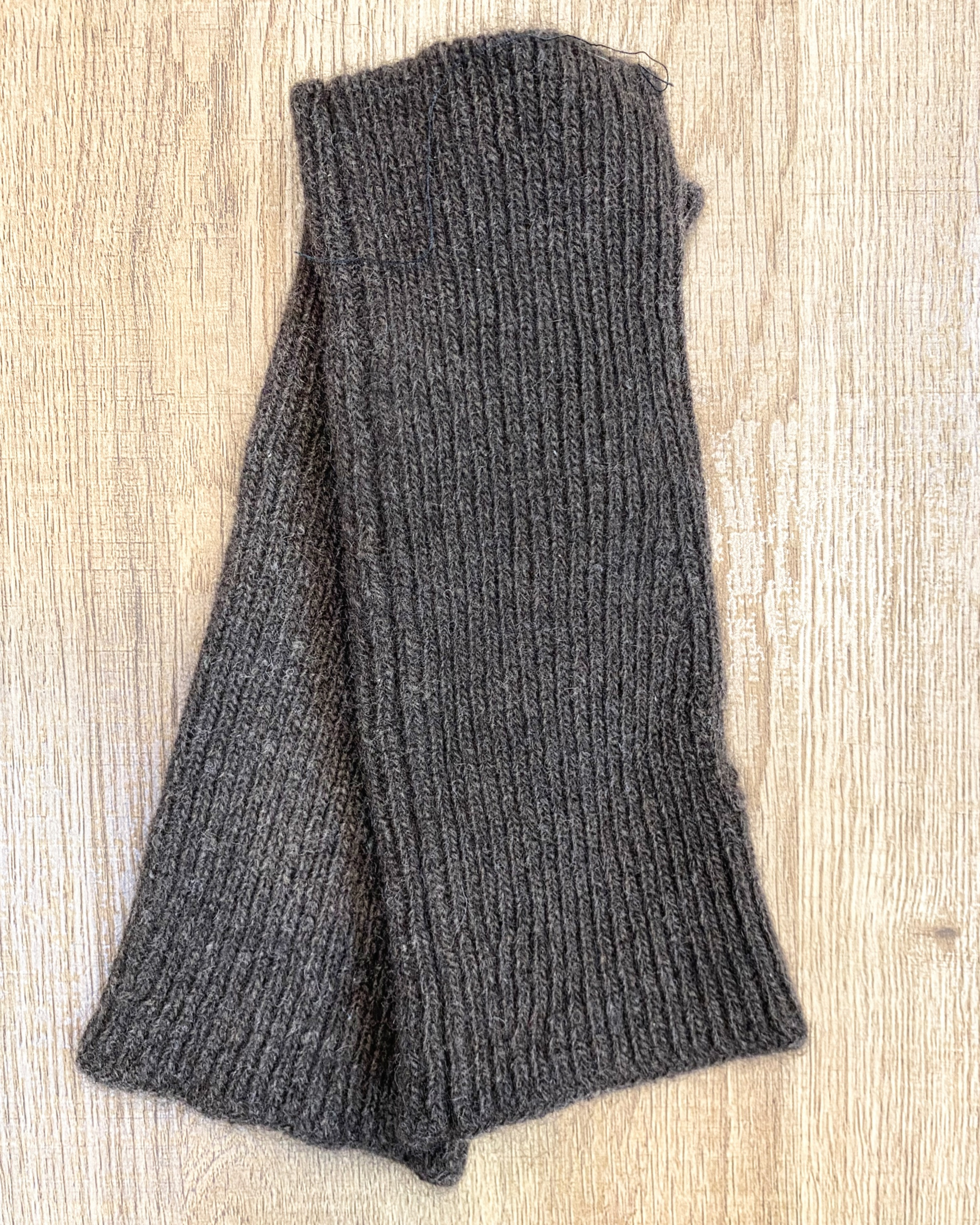 Dark brown yak wool hand warmers on neutral background, flat view