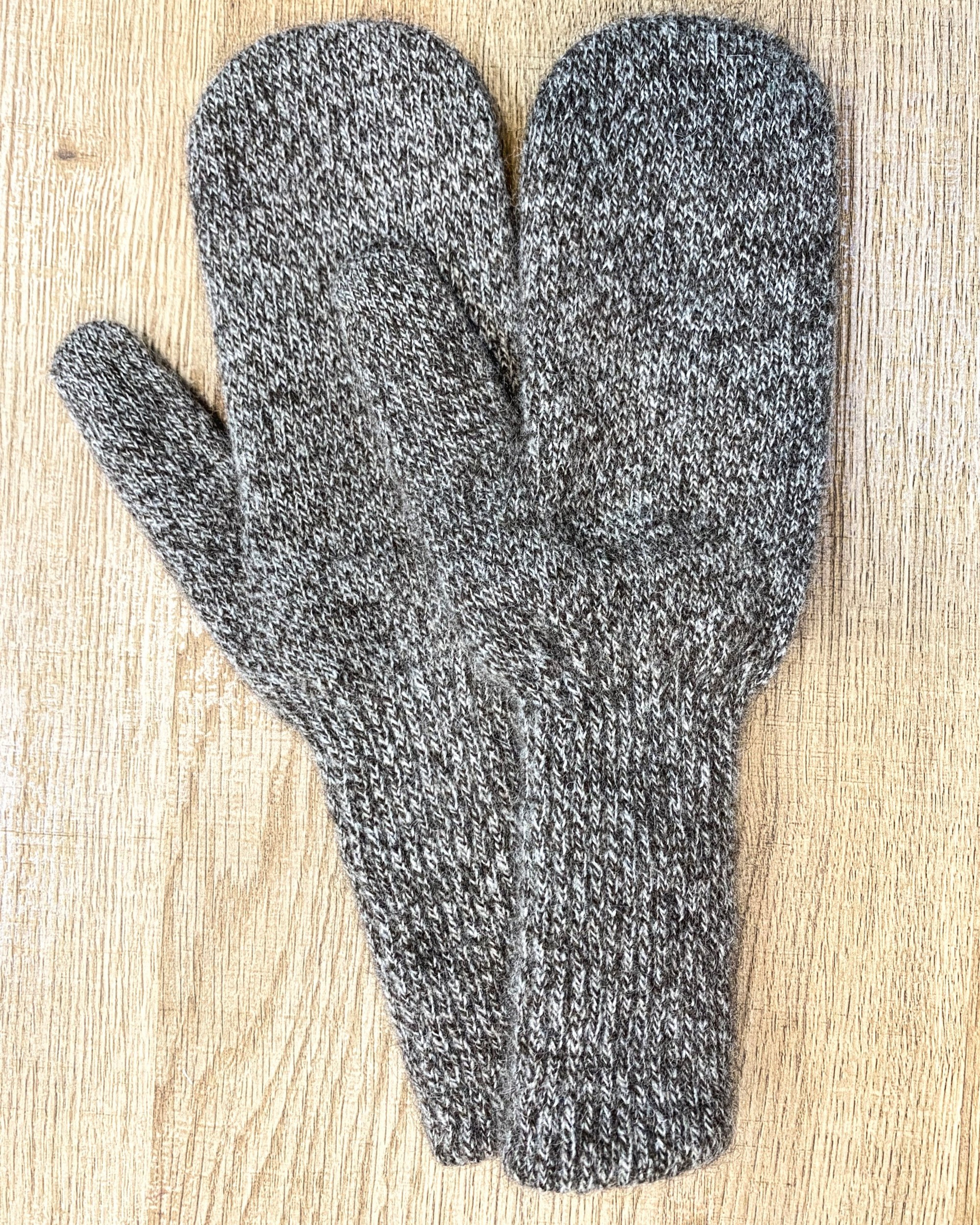 Mottled brown yak wool mitten gloves on neutral background, flat view