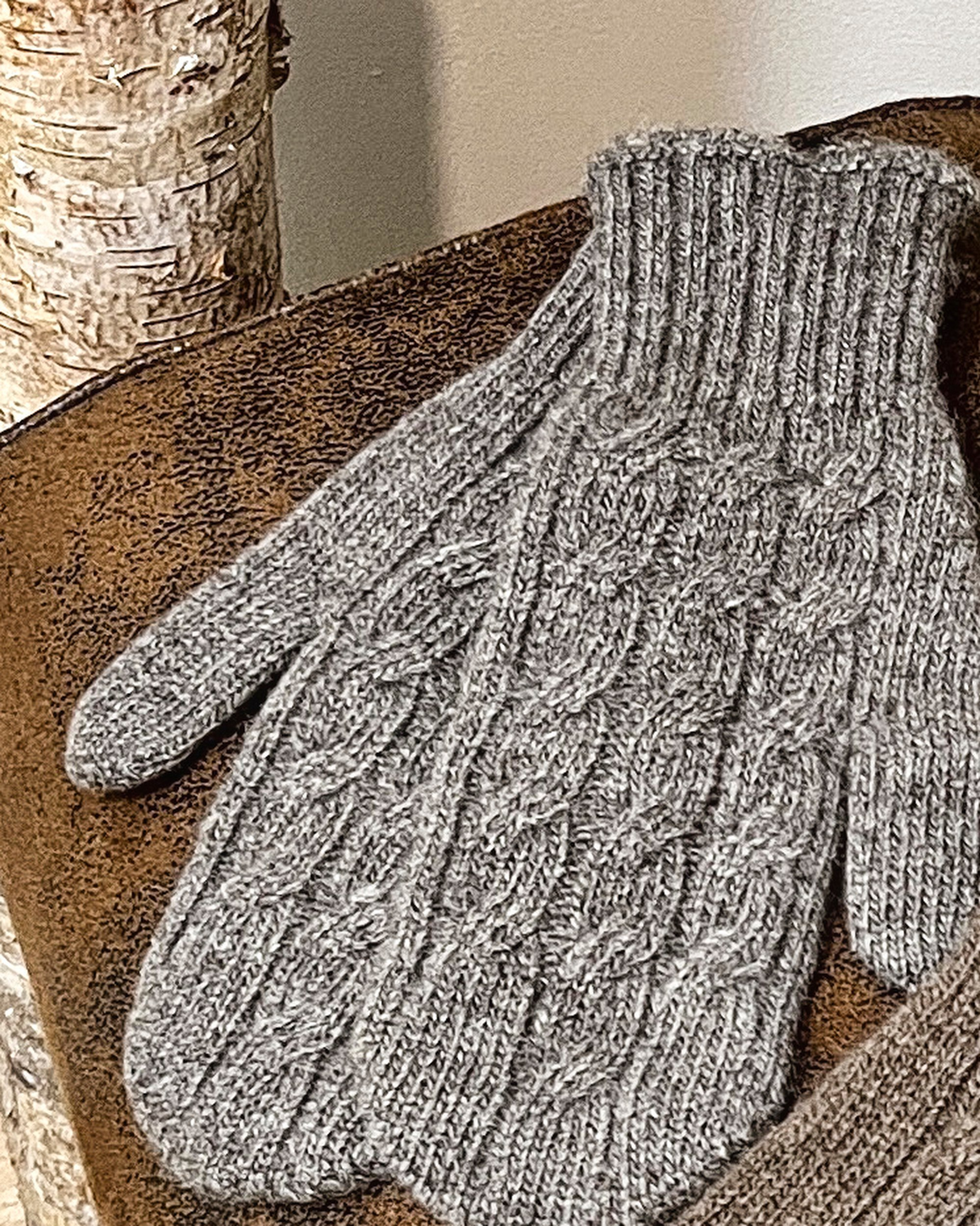 Natural brown yak wool mitten gloves on neutral background, flat view