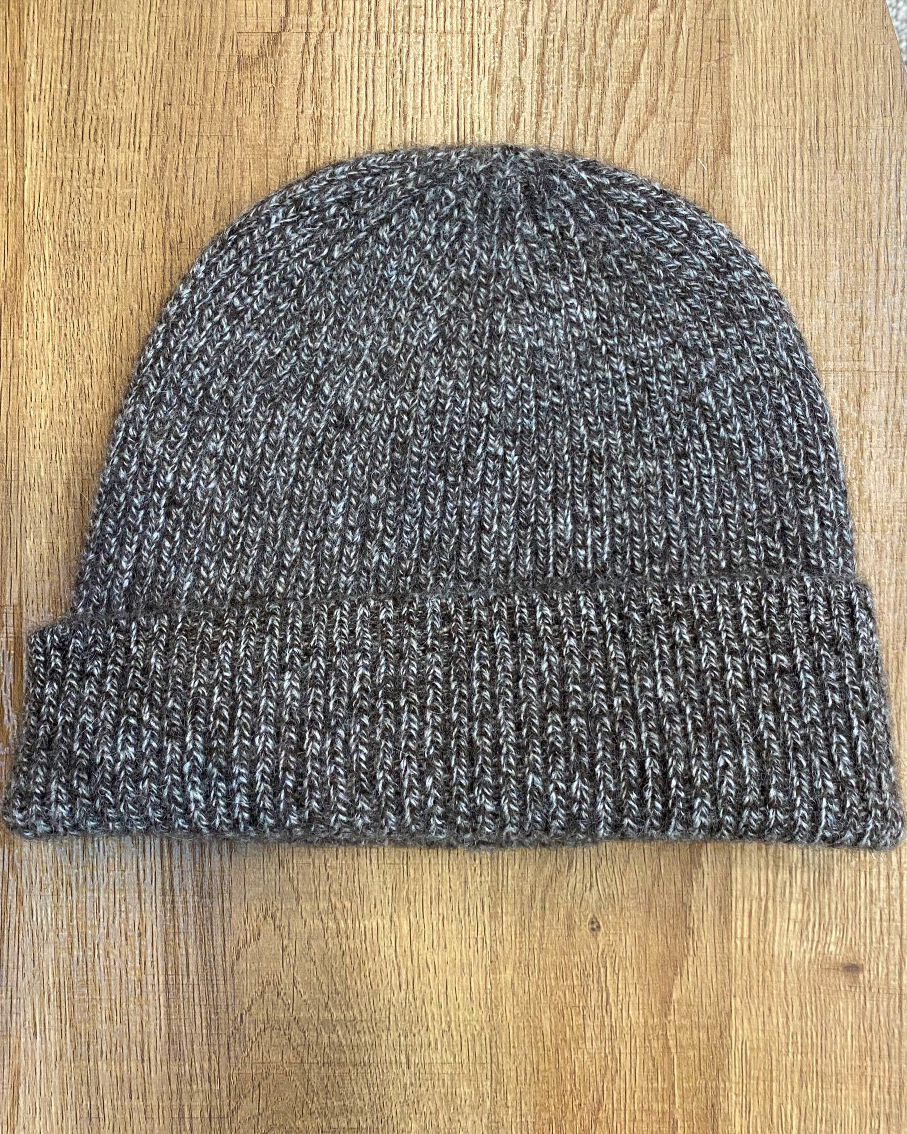 Mottled brown yak wool hat on neutral background, flat view