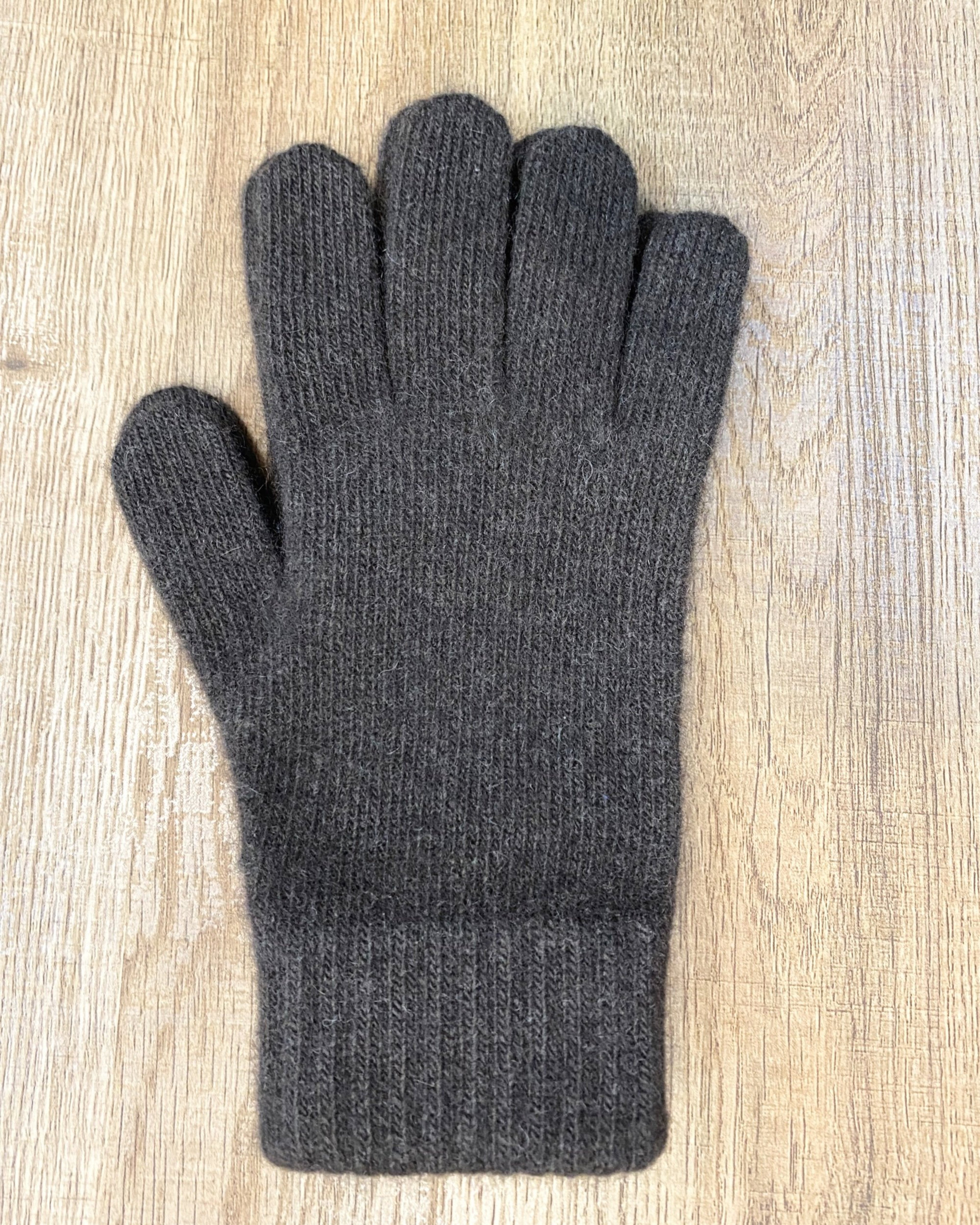 Dark brown yak wool gloves on neutral background, flat view