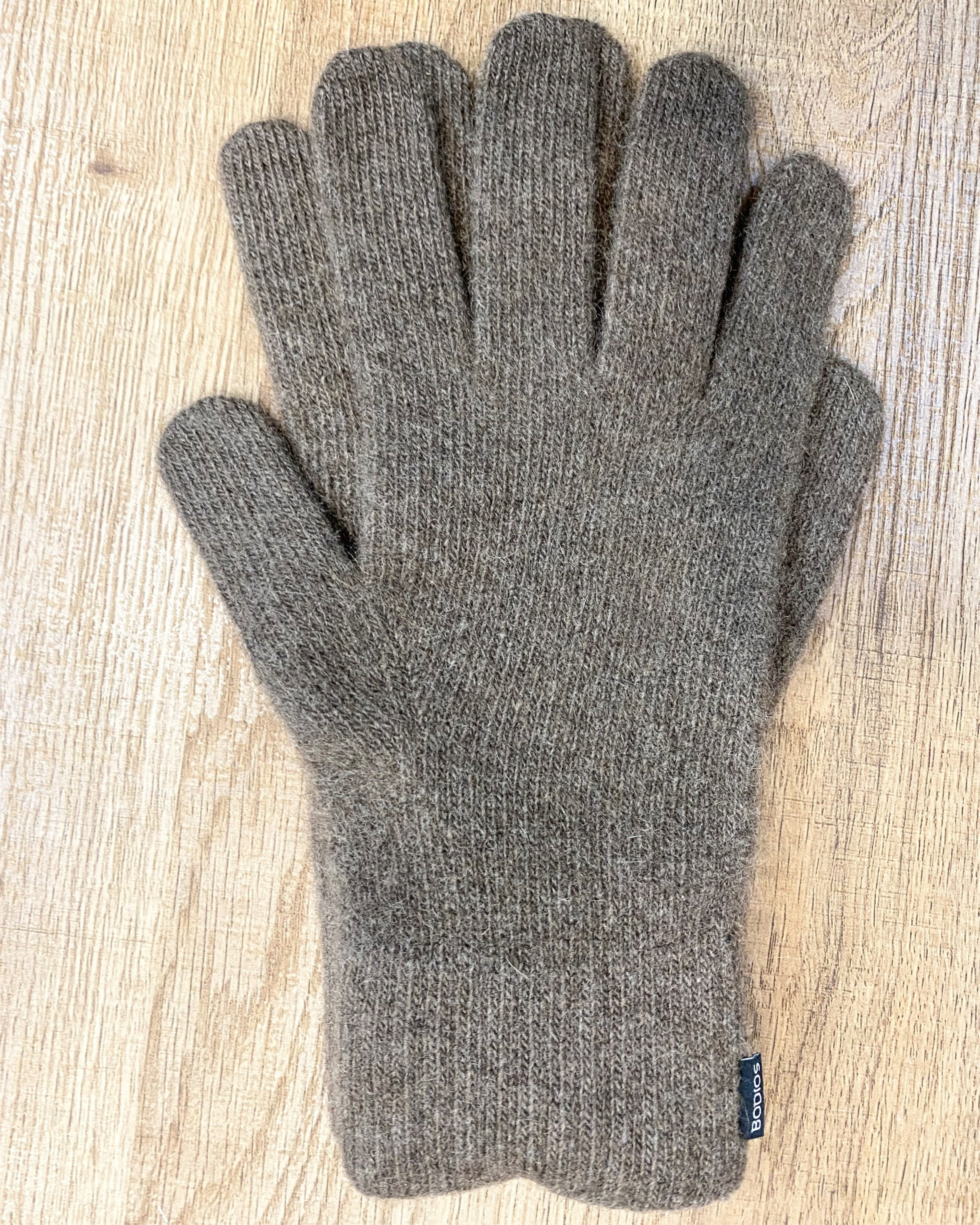 Natural brown yak wool gloves on neutral background, flat view