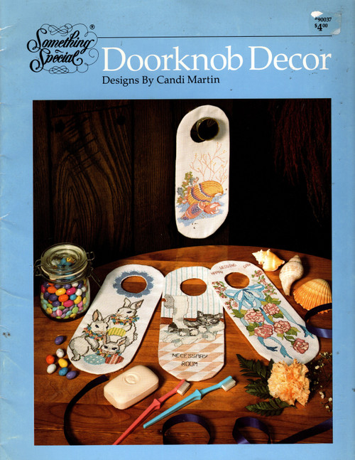 Something Special Doorknob Decor counted cross stitch booklet. Bluebirds and Flowers, Chickadees, Fall Leaves, Spring Floral, Shells, Ribbons and Roses, Christmas Ducks, Backdoor Guests, Necessary Room, Leprechaun, Rabbits and Eggs, Boo, Halloween Cat and Pumpkin, Santa, Patchwork Bear