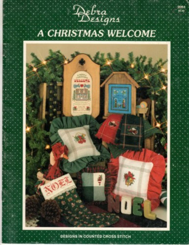 Debra Designs A Christmas Welcome counted cross stitch booklet. Debra Lambein. Santa Claus, Season's Greetings, Happy Holidays, Red Robed Angel, Green Robed Angel, Remember the Reason, A Merry Christmas Welcome, Twp Joyous Noel Angels, Three Noel Angels, Keep the Spirit of Christmas, Script Noel, Mini Santa