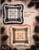 Aggie J Presents Hopscotch Revival Cross Stitch Pattern leaflet. Large design in brown and blue color scheme, Side Border, Corner Square Graph.