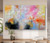 Large horizontal abstract painting on a light wall above a wooden console. 