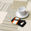Wipe Clean Tablecloth Fabric. Mirha: Patchwork - Pictured with cup,saucer, phone and pen.