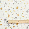 Navarra Silver & Gold Stars Acrylic Coated Fabric. Pictured with a wooden rule.