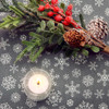Living: Snowflake Grey Acrylic Coated Wipe Clean Christmas Fabric. Pictured with a votive candle tealight and seasonal greenery