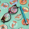 Wipe Clean Tablecloth - Digital Floating. Pictured on a table with a pair of glasses and a pen