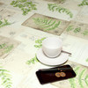 Wipe Clean Tablecloth - Navarra: Herbs.  Pictured with a 'phone, pen, cup and saucer.