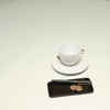 Acrylic coated tablecloth: Murcia Munch. Pictured with a cup and saucer, 'phone, pen and coins