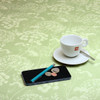 Extra Wide Wipe-Clean Fabric: Navarra: Ceres Verde. Pictured with a cup and saucer, 'phone and pen.