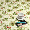 Wipe Clean Christmas Tablecloth. Living Winter Berries. Pictured with a cup and saucer, 'phone, pan and coins.