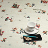 Acrylic Coated Christmas Tablecloth: Culla Carols - pictured with a cup and saucer, 'phone, pen and coins.