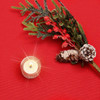Ibiza Yarn Dyed: Festive Red -  wipe clean acrylic coated tablecloth pictured with a votive tealight candle and seasonal greenery.