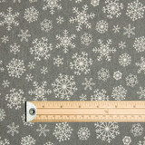 Living: Snowflake Grey Acrylic Coated Wipe Clean Christmas Fabric. Pictured with a wooden ruler to illustrate scale.