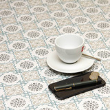 Acrylic Coated Tablecloth - Living: Victorian Tiles - pictured with a phone, pen, cup and saucer