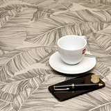 Wipe Clean Tablecloth - Mirha Tropical Leaf - pictured with a cup, saucer, phone and pen