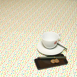 Navarra: Lina.  Acrylic Coated Tablecloth, pictured on a table with a cup and saucer,  'phone, pen and coins.