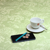 Extra Wide Wipe-Clean Fabric: Navarra: Ceres Verde. Pictured with a cup and saucer, 'phone and pen.
