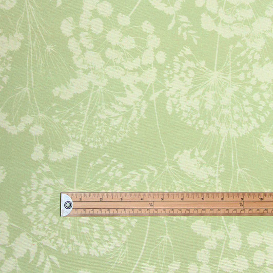 Extra Wide Wipe-Clean Fabric: Navarra: Ceres Verde. Pictured draped on the corner of a dining table.