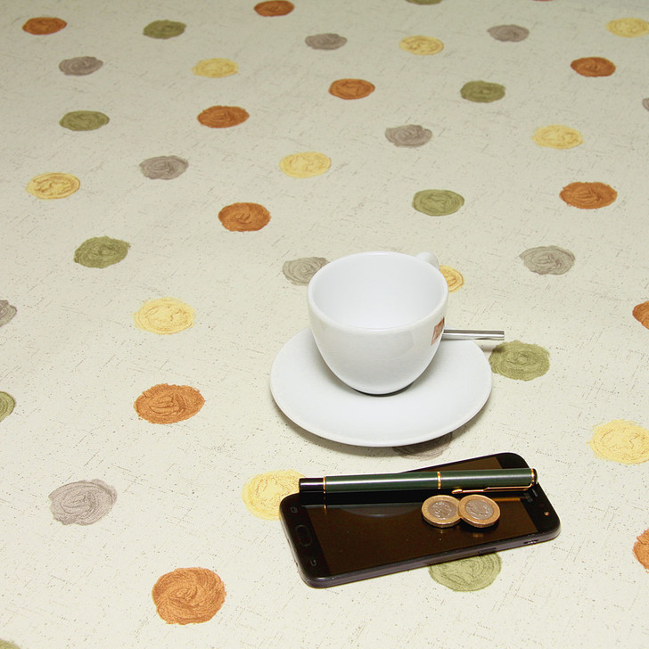 Acrylic Coated Tablecloth Loneta: Leon - Terracotta. Pictured with a cup and saucer, 'phone and pen.