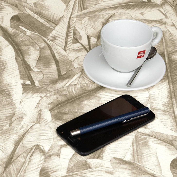 Wipe Clean Tablecloth - Navarra: Leaves - Brown. Pictured with a cup and saucer, 'phone and pen.