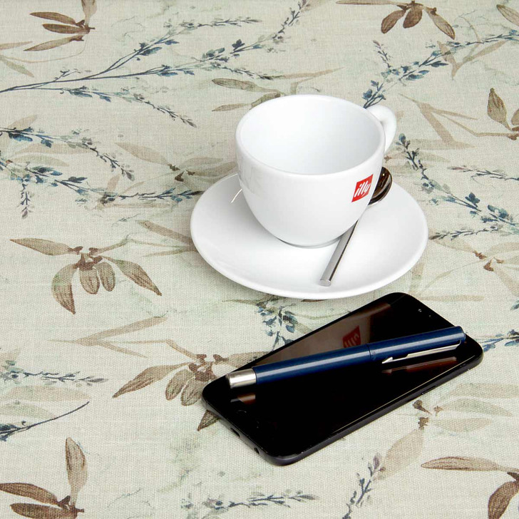 Digital : Verdara. Wipe Clean Tablecloth pictured on a table with a cup, saucer and phone