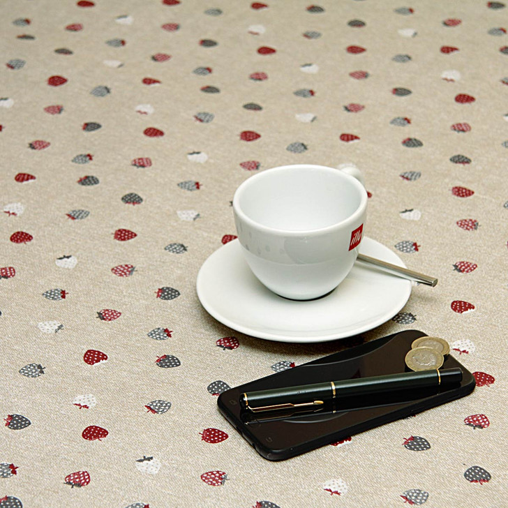 Acrylic Coated Tablecloth - Loneta: Fresa - pictured with a phone, pen, cup and saucer.