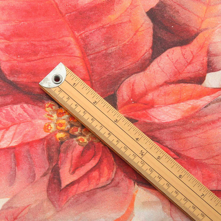 Wipe Clean Fabric - Digital Poinsettia. Pictured with a wooden metre rule to show scale.