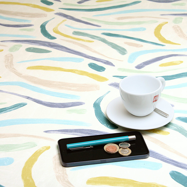 Acrylic Coated Tablecloth - Living:  Brush Strokes - pictured with a cup and saucer, 'phone, pen and coins.