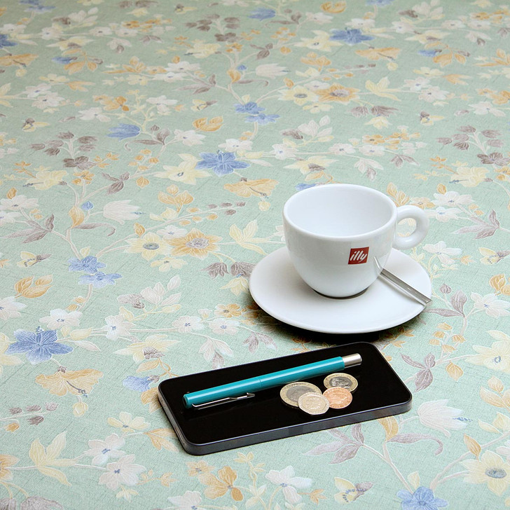 Wipe Clean Tablecloth - Blaze: Orla. Pictured with a cup and saucer, 'phone, pen and coins.