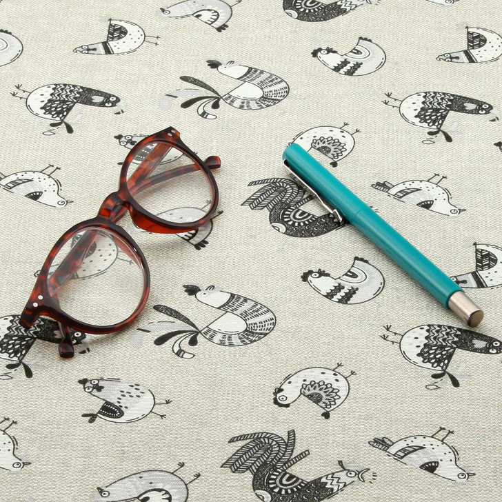 Loneta: Cluck - Wipe Clean Tablecloth - pictured with a pair of glasses and a pen.