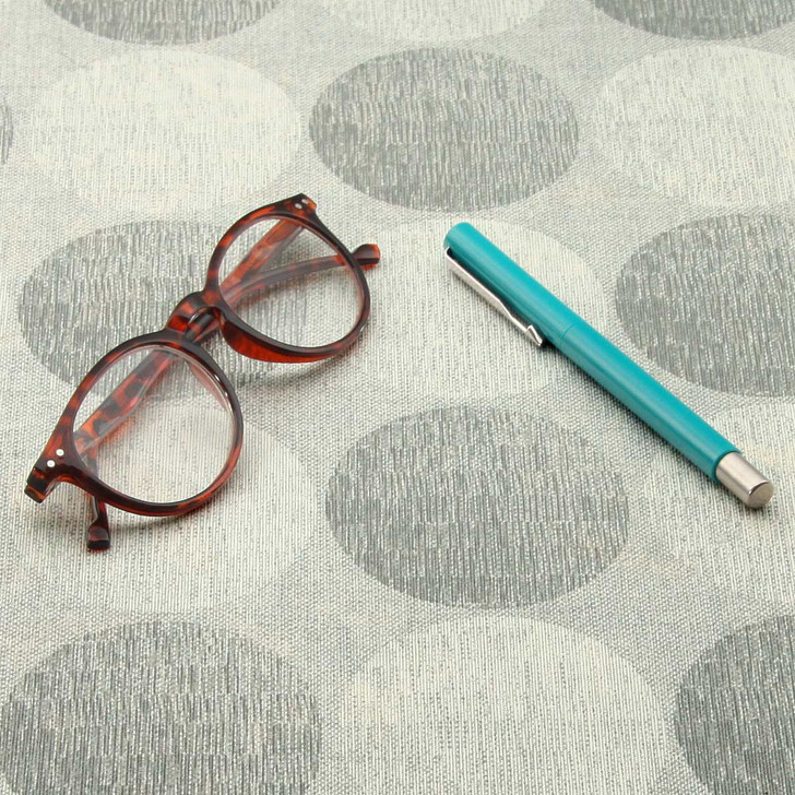 Living Circles - Grey: Wipe Clean Fabric. Pictured with a pair of glasses and a pen.