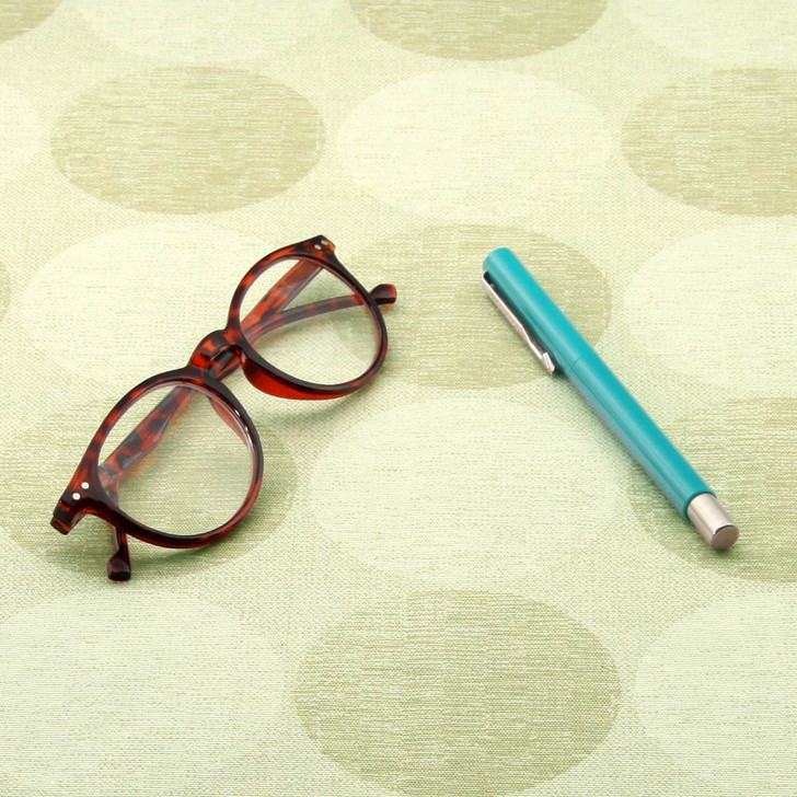 Living Circles - Beige: Wipe Clean Fabric. Pictured with a pair of glasses and a pen.