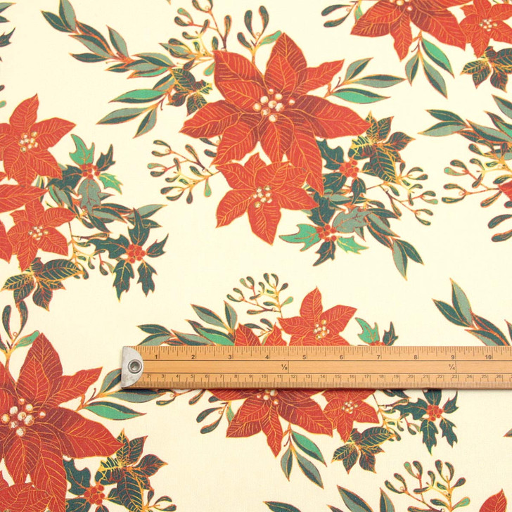 Navarra Christmas Flowers wipe clean acrylic oilcloth fabric pictured with a ruler to show scale.
