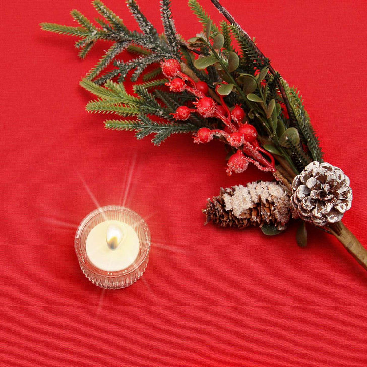 Ibiza Yarn Dyed: Festive Red -  wipe clean acrylic coated tablecloth pictured with a votive tealight candle and seasonal greenery.