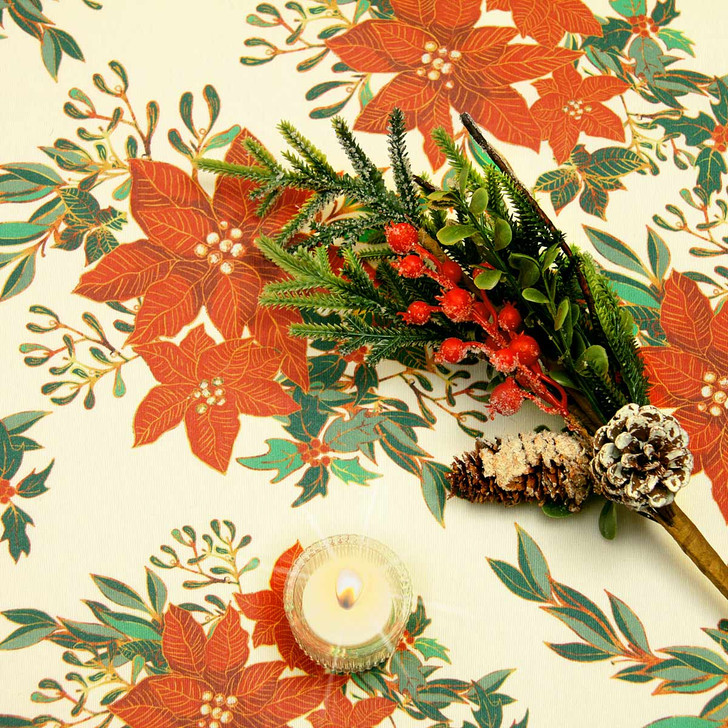 Navarra Christmas Flowers wipe clean acrylic oilcloth fabric pictured with a votive tealight candle and seasonal greenery.