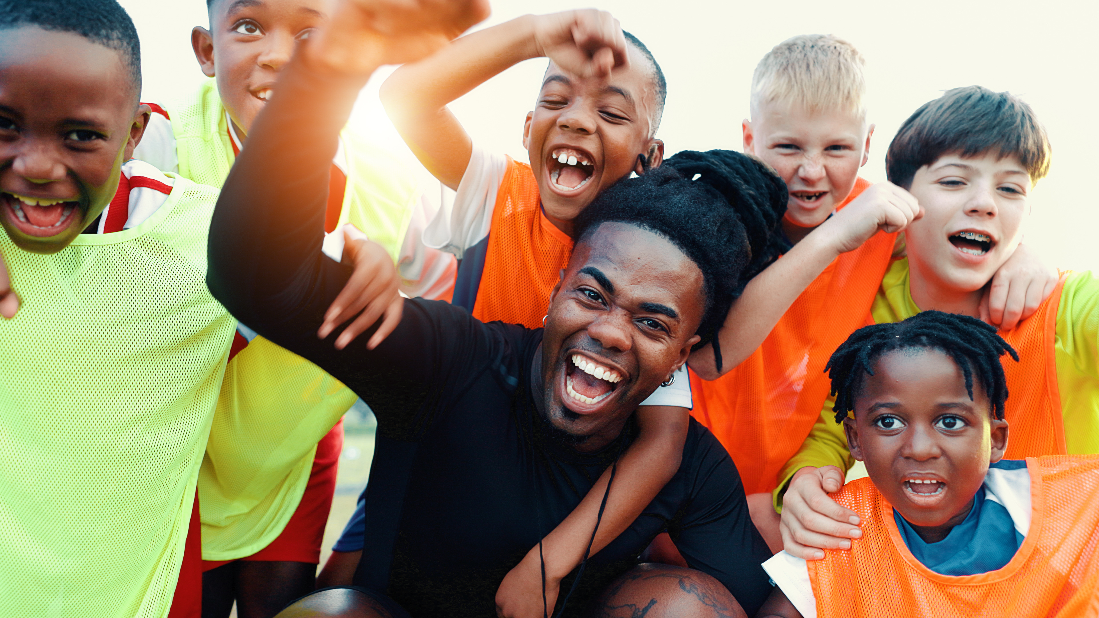 A picture of a boy's football team having fun with their coach.