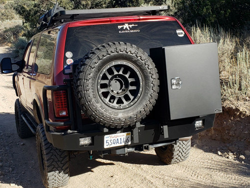 Rear view of an red Excursion van on the wild featuring Aluminess Rear Bumper.