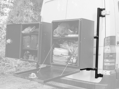 Rear view of a white Mercedes Sprinter van featuring an Aluminess Passenger Side Rear Door Box Rack in the woods.