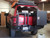 Rear view of an red Excursion van on the wild featuring Aluminess Rear Bumper.