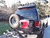 Rear view of an black Excursion van on the wild featuring Aluminess Rear Bumper.