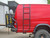 Red Ford E-Series van equipped with a black side ladder.