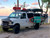 White Ford E-Series van equipped with a black side ladder and surf boards.