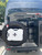 Close-up picture featuring a RotopaX White 2 Gallon Fuel Container on the rear door of a van.