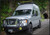 A white Nissan NV van with a black powder coated off-road front winch bumper from Aluminess Products.